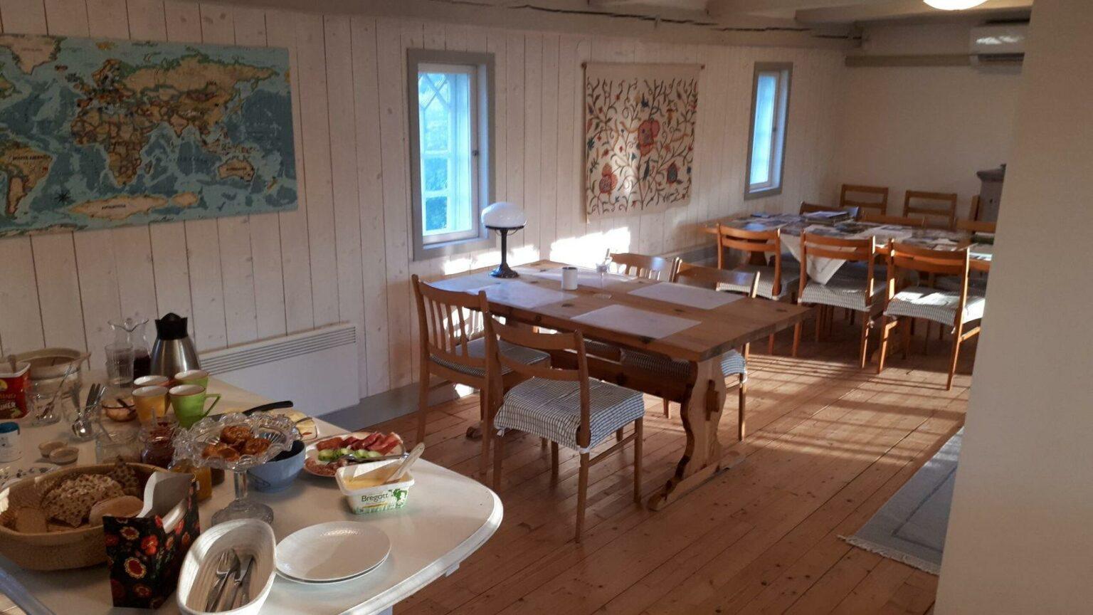 Matsal med bord och stolar. I förgrunden står en frukostbuffé uppdukad.