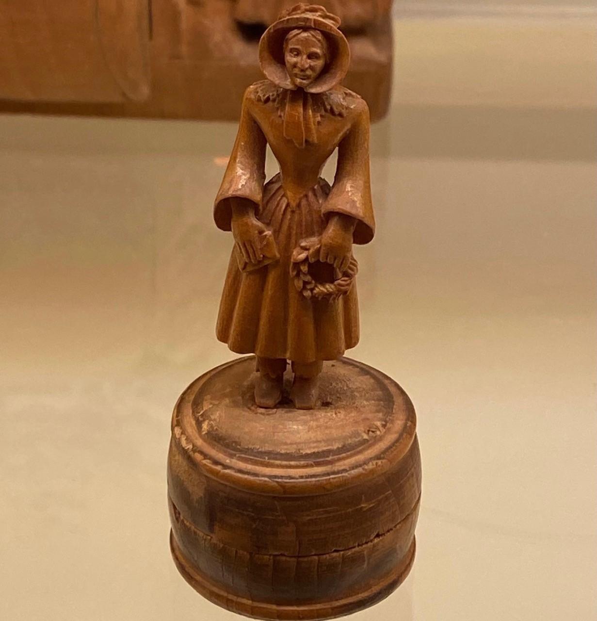 En träskulptur av en gammal kvinna.