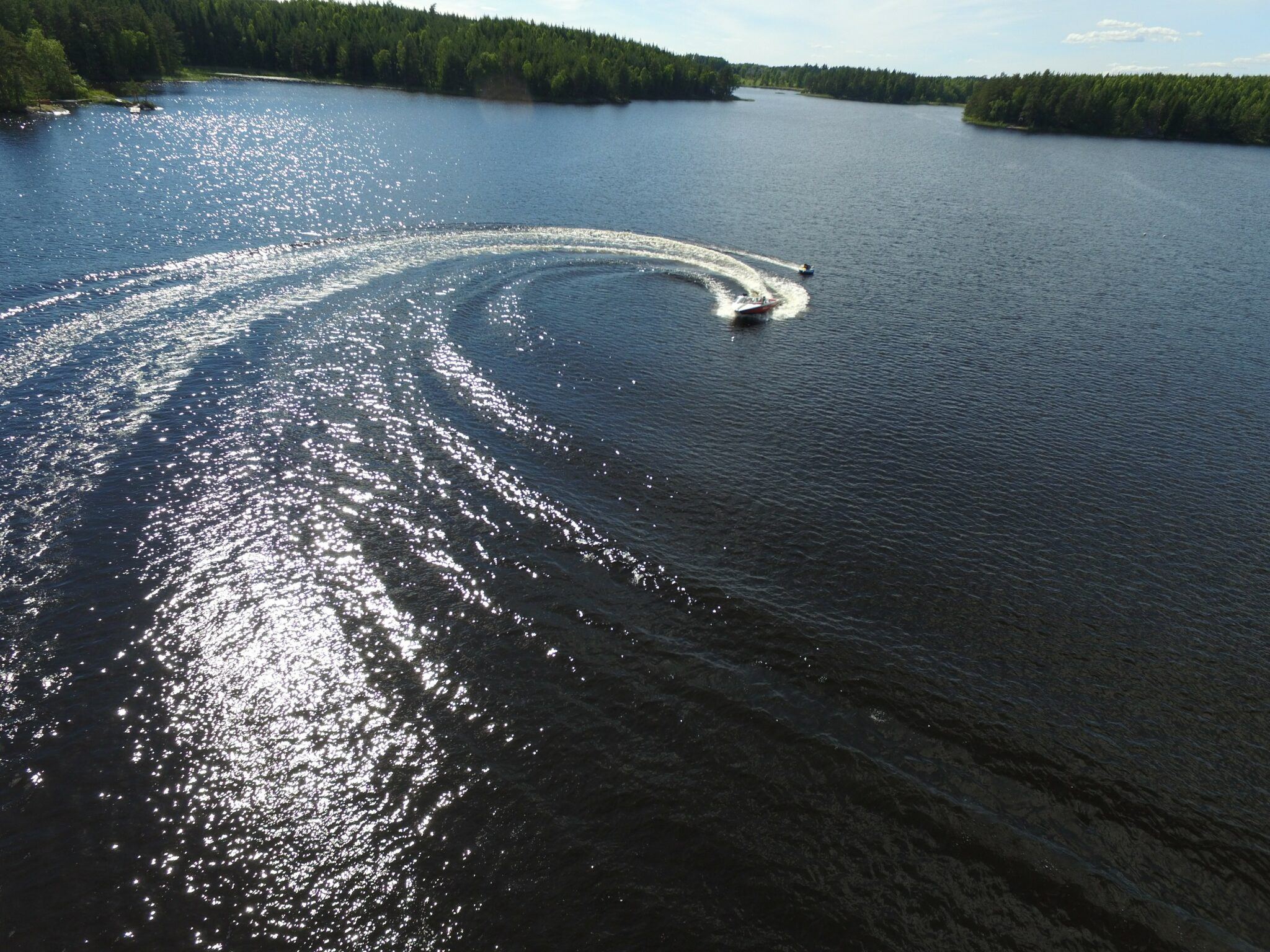 Drönarfoto på en motorbåt som svänger kraftigt på en sjö.