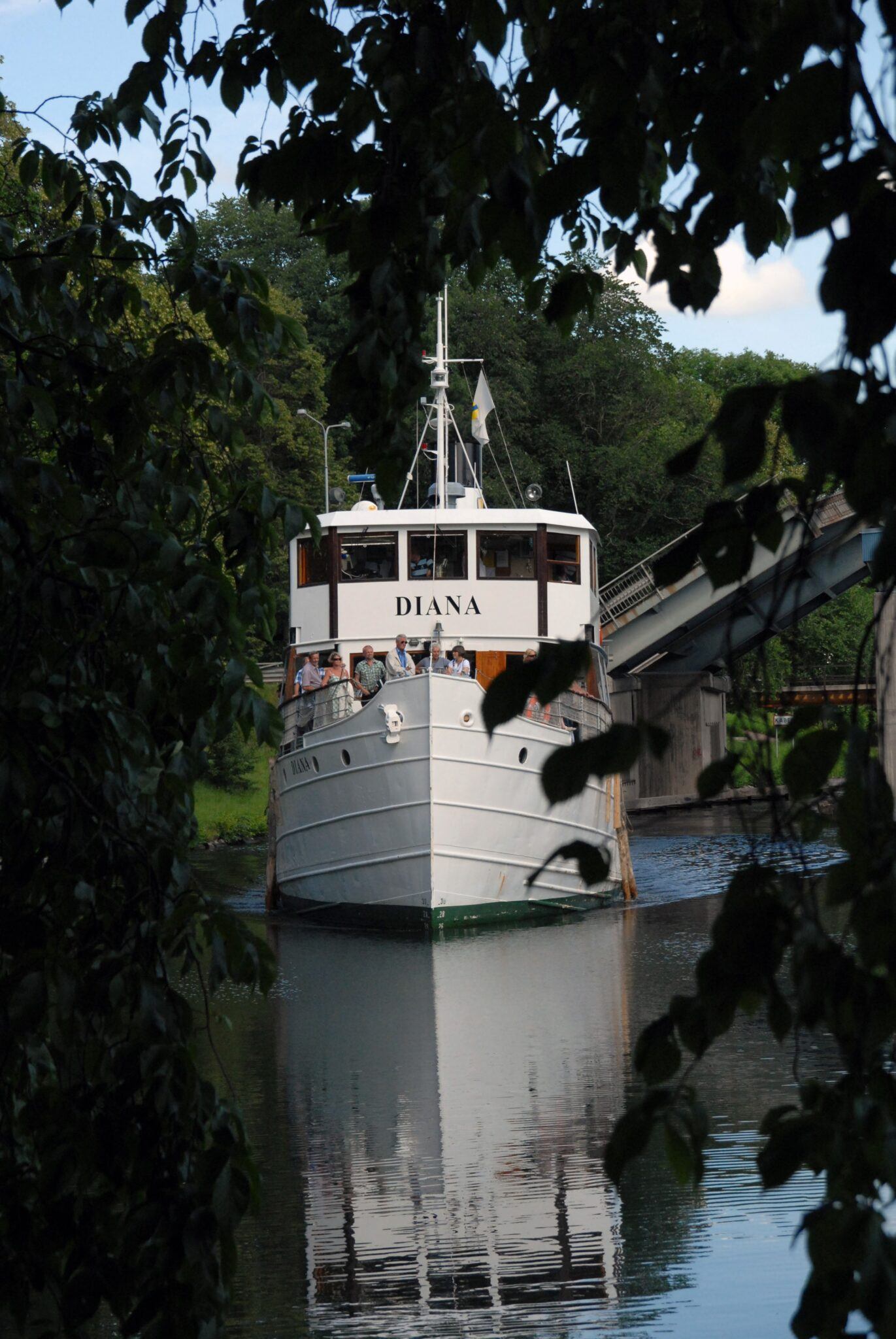 Stor vit passagerarbåt glider fram i Göta Kanal.