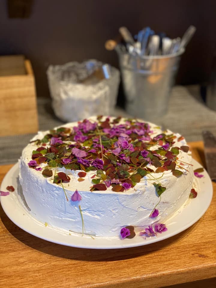 En vit tårta med lila blommor