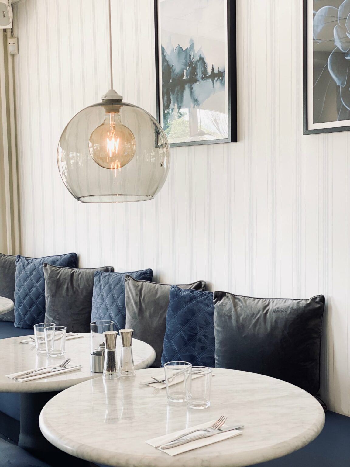 En ljus interiörbild från en restaurang med bord och soffa i blickfånget.