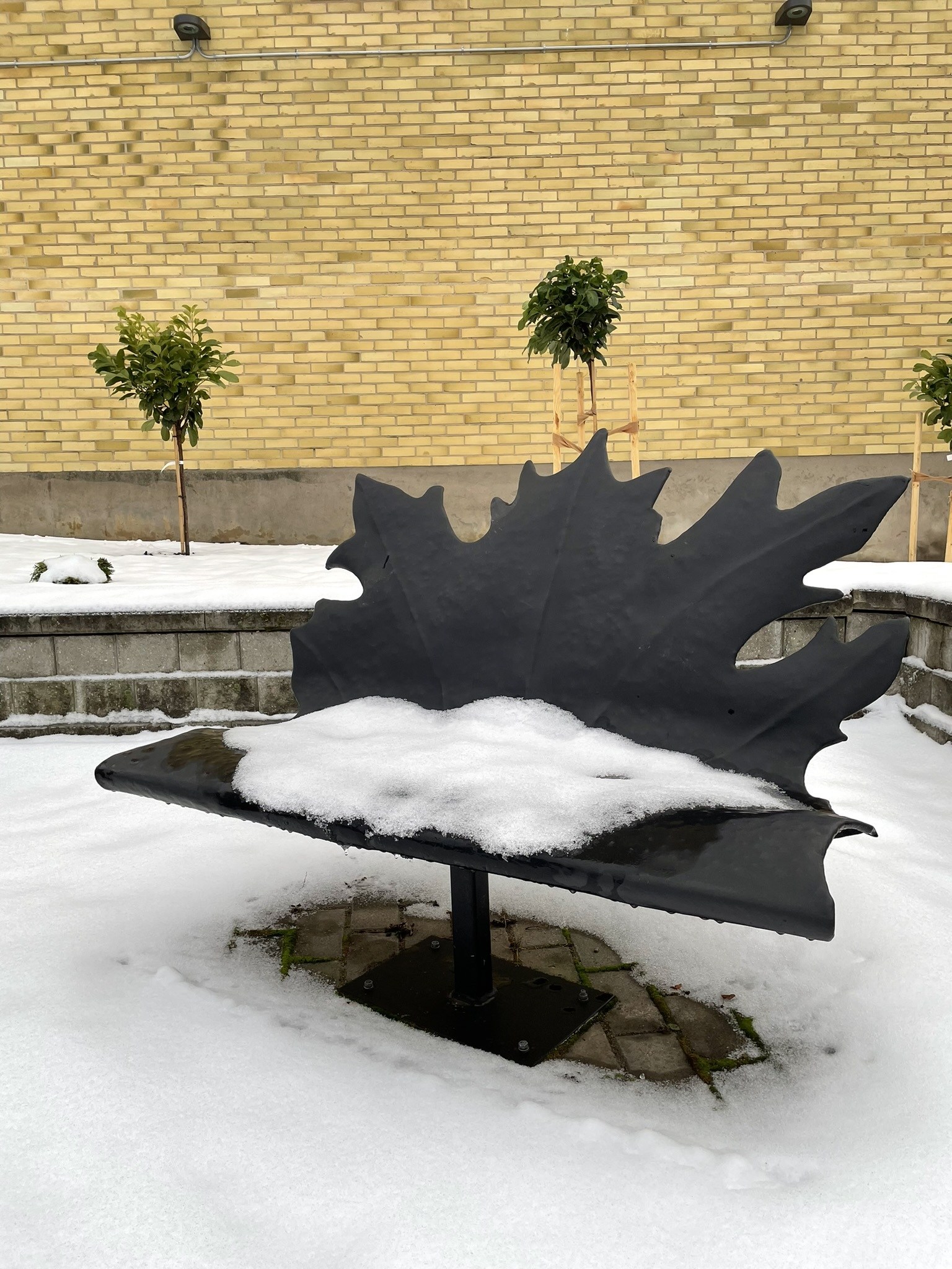 Soffan på Jungfru Isbergs plats i gamla stan påminner om ett löv skapat i någon form av svart plåt.