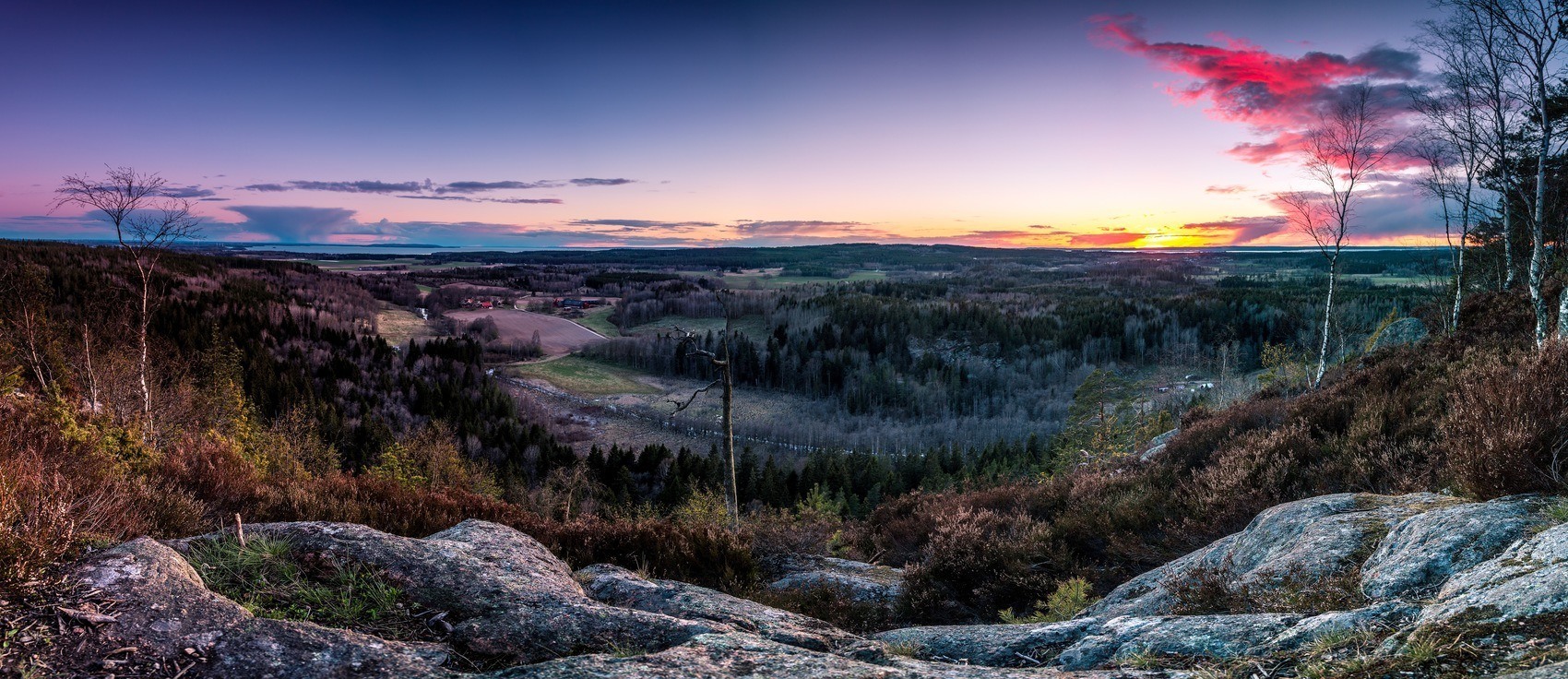Magisk utsikt från Håleberget över ett landskap i solnedgång.