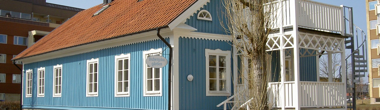 Ett blått hus med vita knutar.