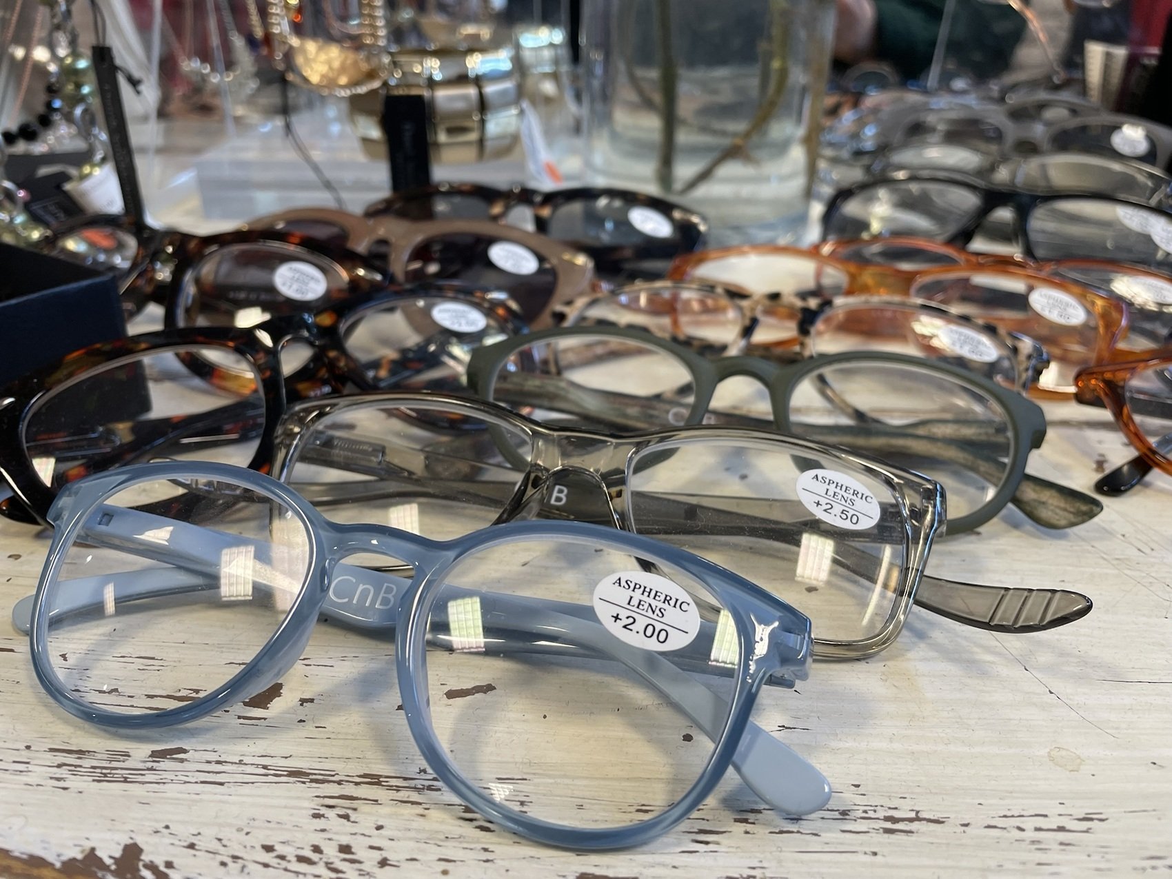Fletalet glasögon i olika färger ligger på ett vitt bord.