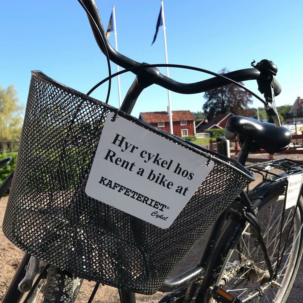 Närbild på en svart cykel med korg. På en skylt på korgen står det "Hyr en hos Kaffeteriet".