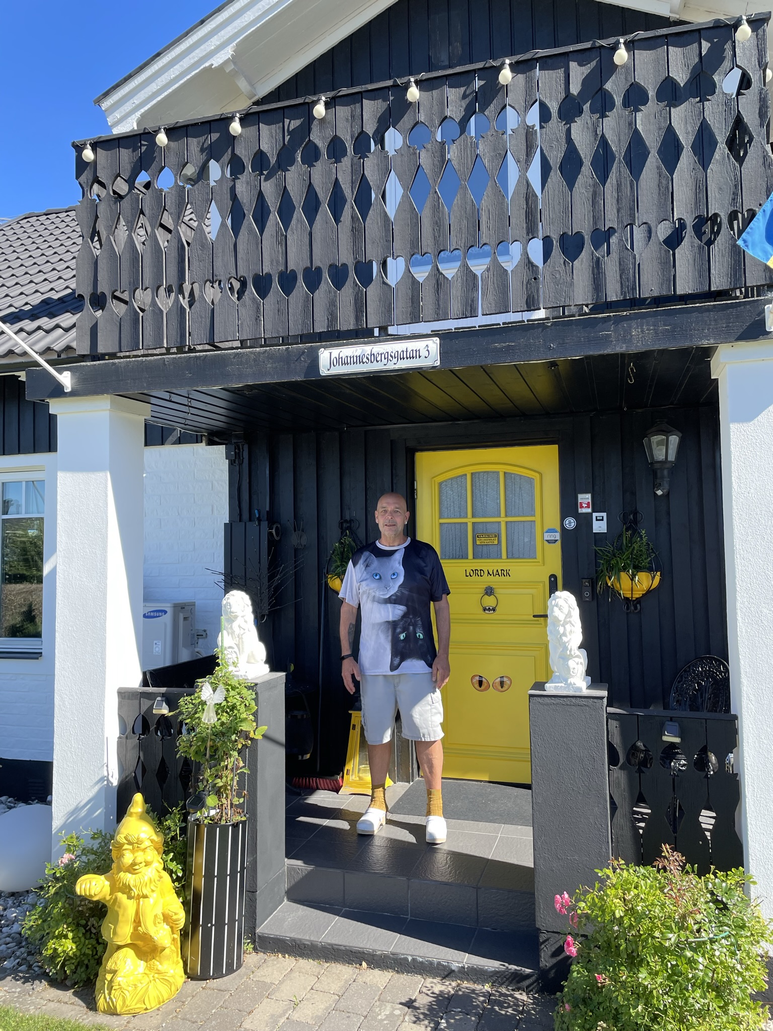 Lord Mark Henriksson är vinnare i tävlingen "Motalas häftigaste hem" 2022. Mark står på trappan framför sin gula ytterdörr.