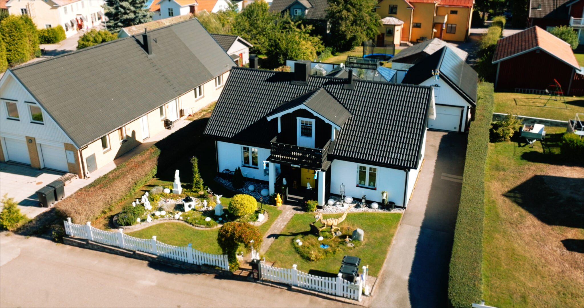 Ett vitt hus med svart tak fotograferat ovanifrån med drönare. Det är en av finalisterna i "Motalas häftigaste hem" 2022.