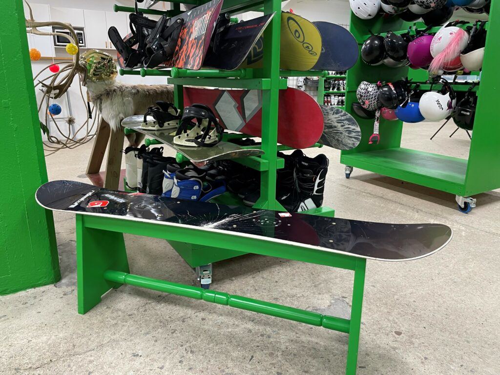 En trasig snowboard har fått gröna ben och ser nu ut som en pall.