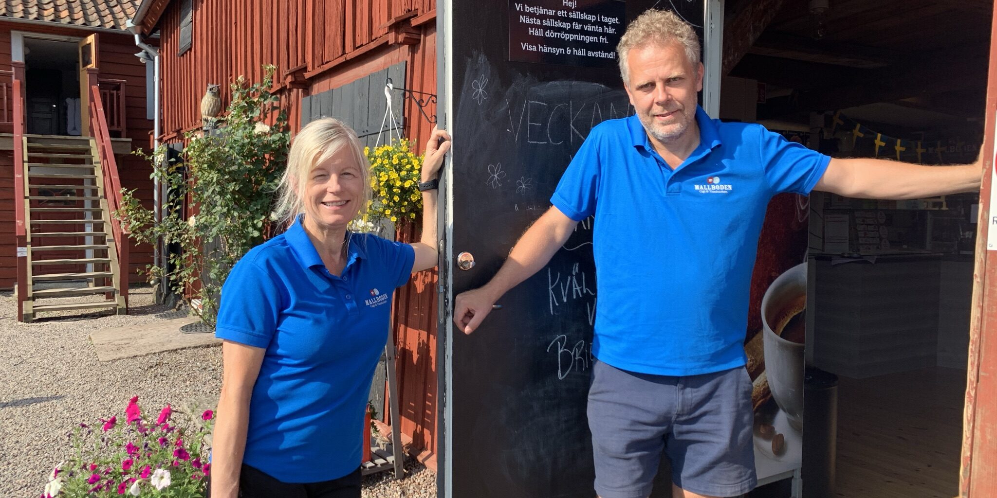Ann Lövgren och Thomas Isacsson är ägare av Mallbodens Café och våfflor. De står i sina blå pikettröjor intill entrédörren till cafeet.